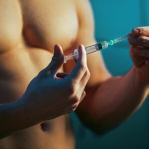 Close up of muscular athlete with injection of performance-enhancing drugs.